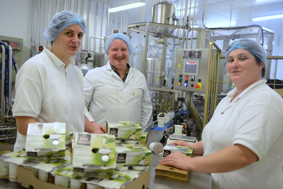 Artisan de la laiterie Ker Ronan en train de préparer des yaourts fermiers, illustrant le savoir-faire artisanal et le respect des méthodes traditionnelles.